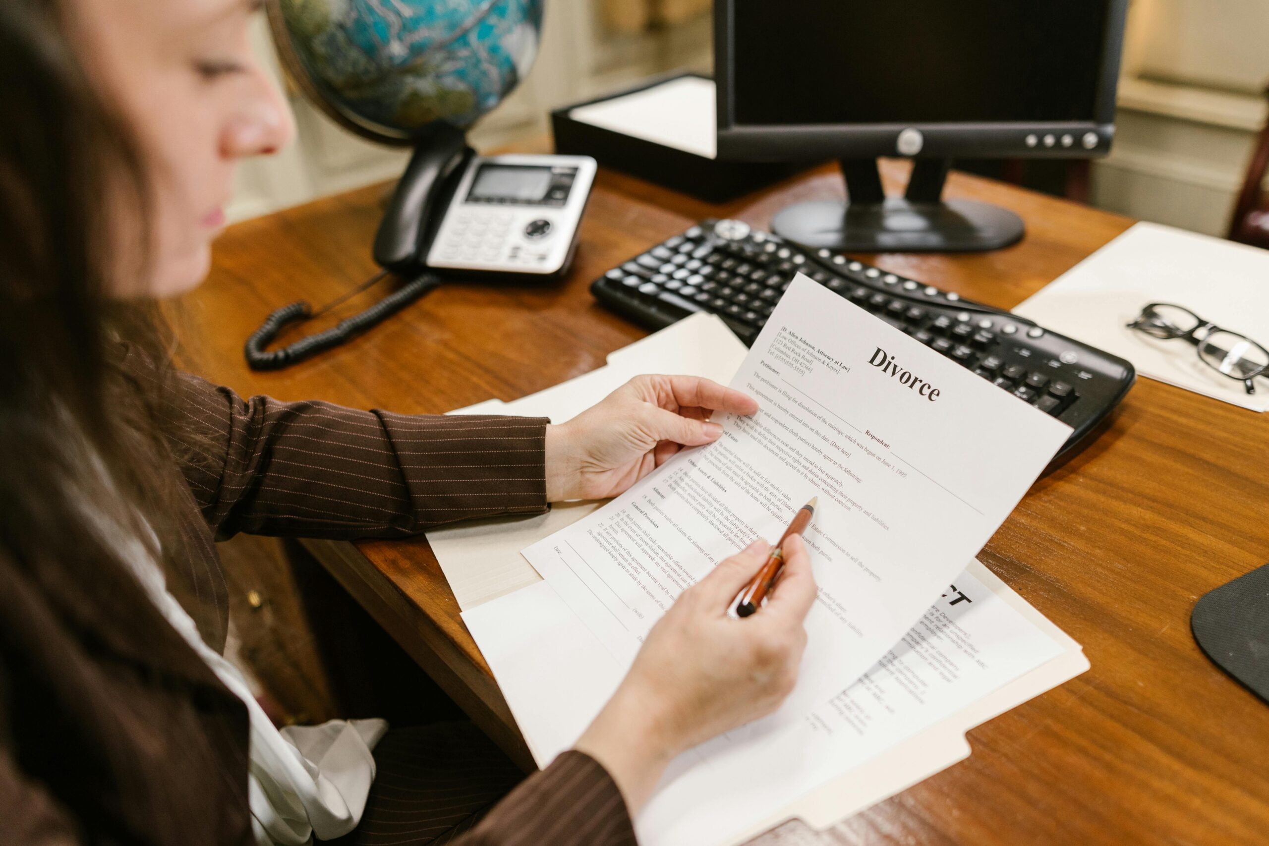 Person reviewing divorce paperwork at a desk, representing family law legal documents