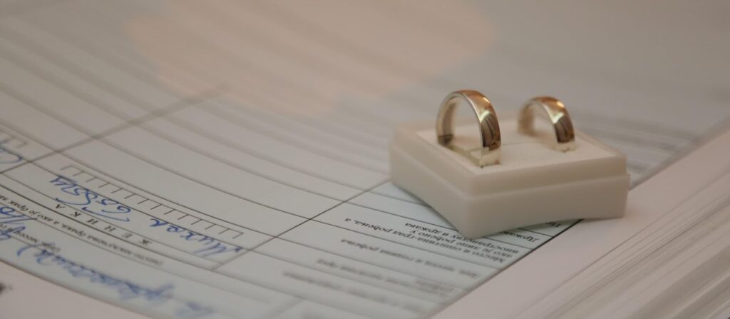 Two gold wedding rings resting on a divorce decree document.