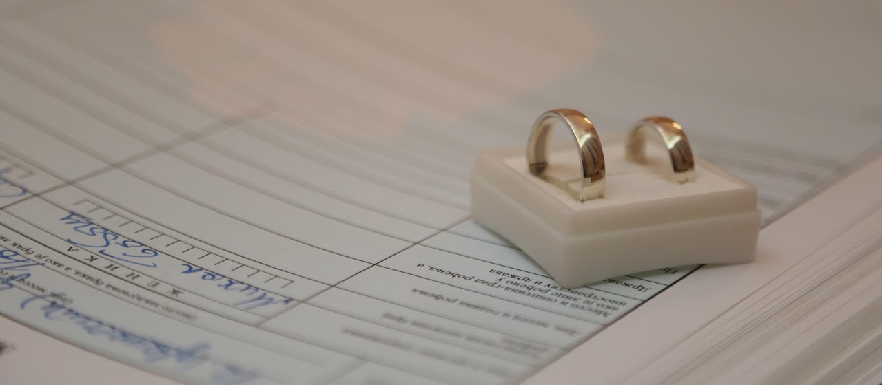 Two gold wedding rings resting on a divorce decree document.