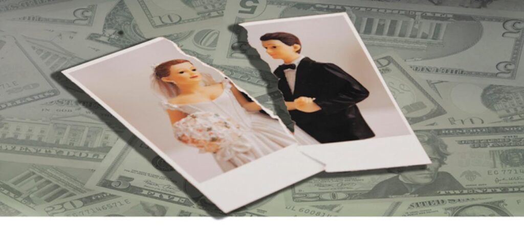 Torn photograph of a bride and groom lying on top of scattered money.