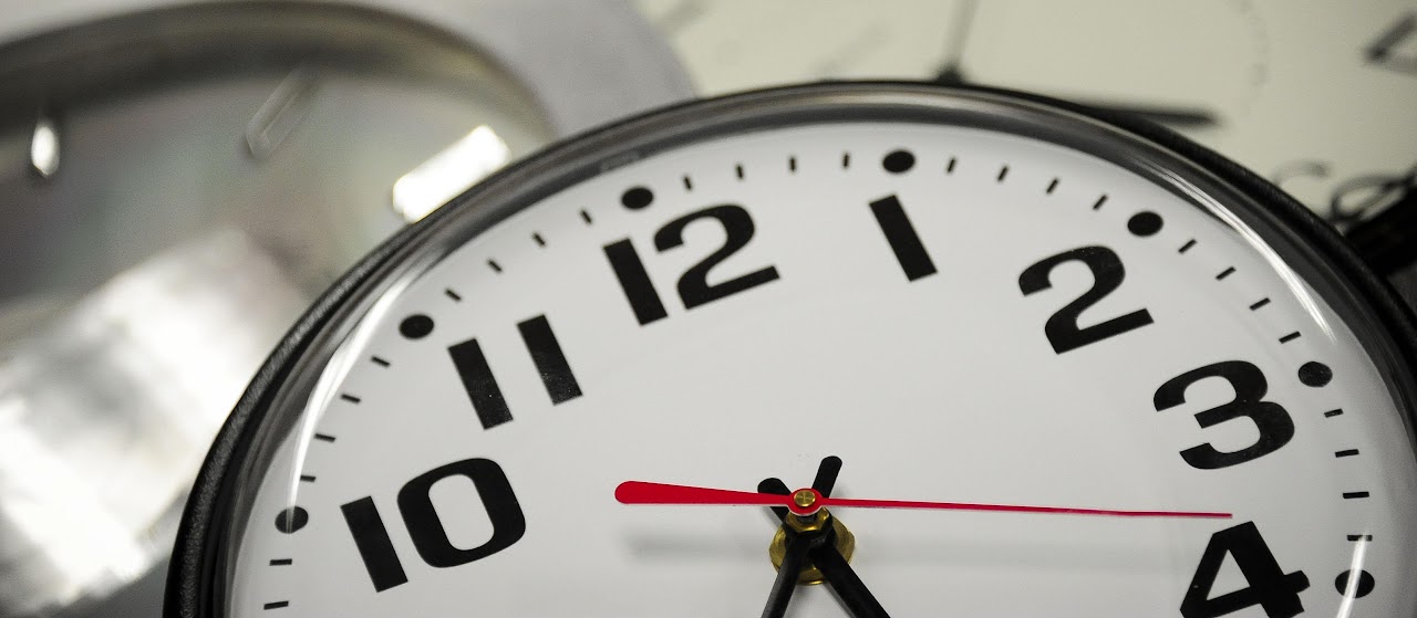 Close-up of multiple clock faces showing different times.