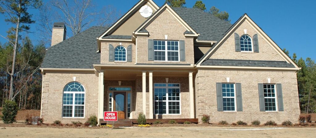 Large brick house with an Open House sign in the front yard.
