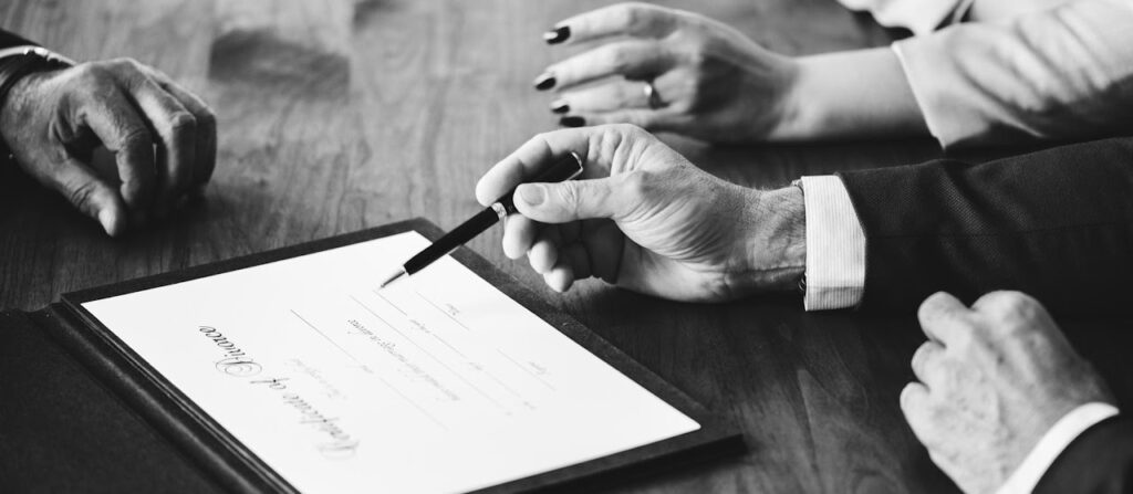 Close-up of hands pointing a pen at a Certificate of Divorce document.