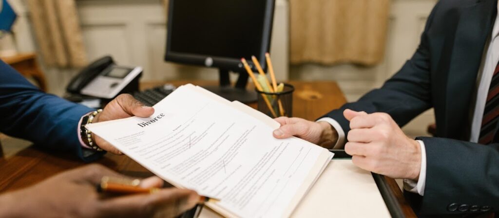 A lawyer handing a document titled Divorce to a client.