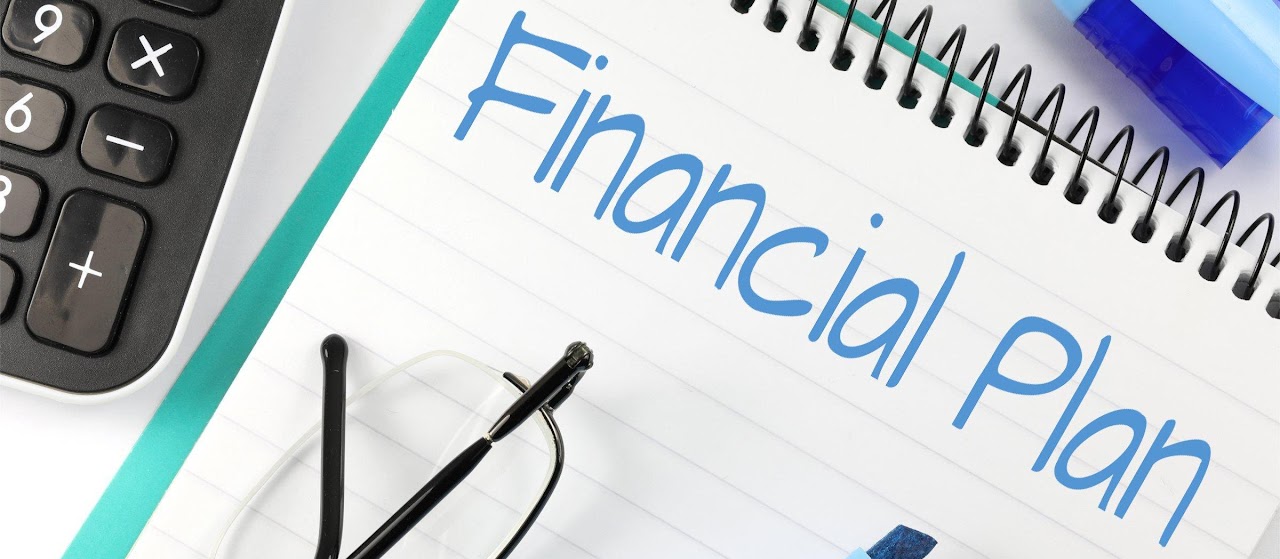 Notebook with the words Financial Plan written on it next to a calculator.
